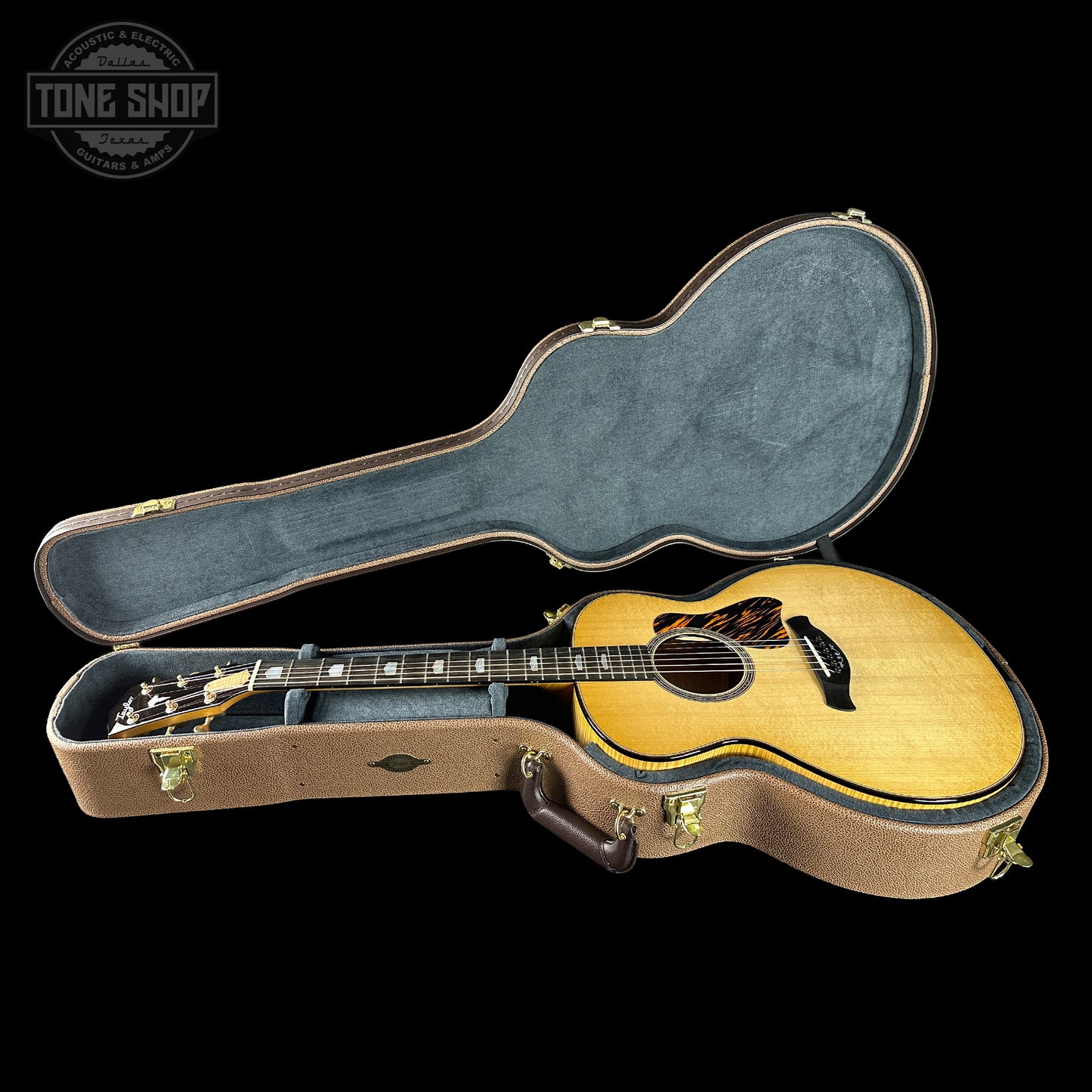 Acoustic guitar in a hard-shell case with 'Tone Shop' logo in the corner.