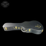 Black guitar case with gold accents on a black background, featuring the Tone Shop logo.