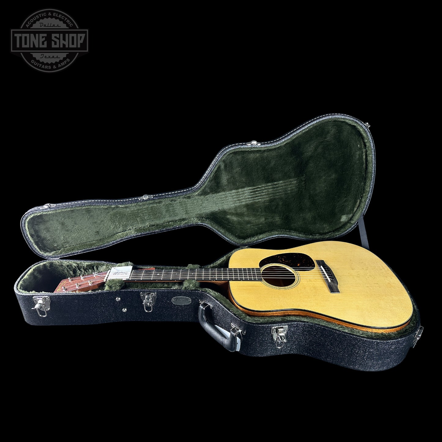 Acoustic guitar in a hard-shell case with 'Tone Shop' logo.