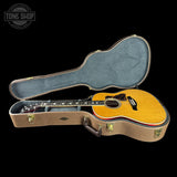 Acoustic guitar in a hard-shell case with 'Tone Shop' logo.