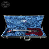Red electric guitar in an open blue case with ESP logo, on a black background.