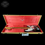 Electric bass guitar in a red-lined case with a visible brand logo on a black background.