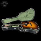 Acoustic guitar in a hard-shell case with 'Tone Shop' logo.