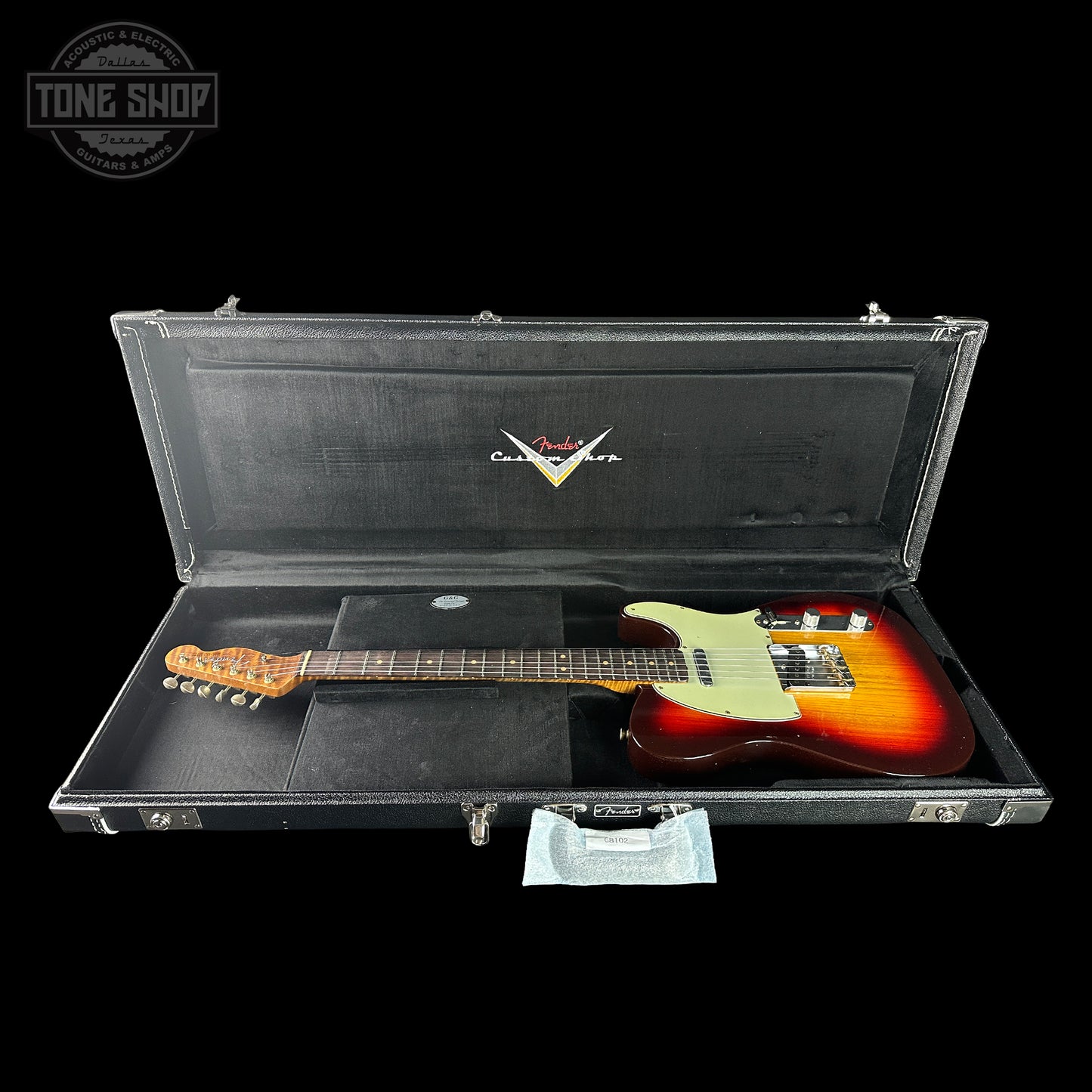 Fender electric guitar in a black case with Fender logo on a black background