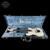 White electric guitar in a blue case with 'Tone Shop' branding.