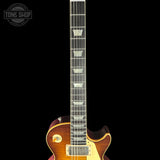 Close-up of a guitar neck with a visible brand logo in the corner.