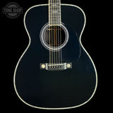 Black acoustic guitar on a black background with 'Tone Shop' logo.
