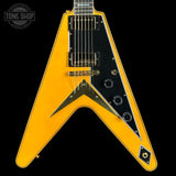 Yellow electric guitar with black pickguard on a black background, featuring 'Tone Shop' logo.