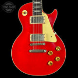 Red electric guitar with gold hardware on a black background, featuring 'Tone Shop' logo.