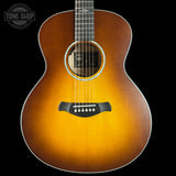 Acoustic guitar with a sunburst finish on a black background, featuring the Tone Shop logo.