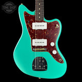 Turquoise electric guitar with a dark wood fretboard on a black background, featuring 'Tone Shop' branding.