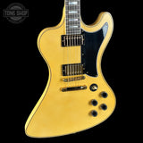 Yellow electric guitar with a black pickguard on a black background, featuring the Tone Shop logo.