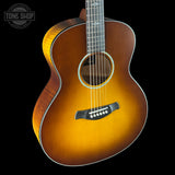 Acoustic guitar with a sunburst finish on a black background, featuring the Tone Shop logo.