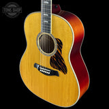 Acoustic guitar with a red accent on a black background, featuring the Tone Shop logo.