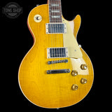 Yellow electric guitar with a 'Tone Shop' logo in the corner