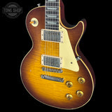 Electric guitar with a sunburst finish on a black background, featuring the Tone Shop logo.