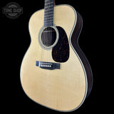 Acoustic guitar with a visible brand logo on a black background