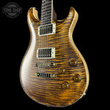 Wooden electric guitar with a black background, featuring the Tone Shop logo.