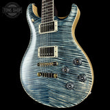 Blue electric guitar with a wavy wood grain pattern on a black background, featuring the Tone Shop logo.