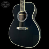 Black acoustic guitar on a black background with 'Tone Shop' logo.