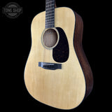 Acoustic guitar with a visible brand logo on a black background