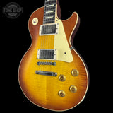 Electric guitar with a sunburst finish on a black background, featuring the Tone Shop logo.