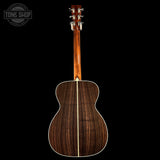 Wooden acoustic guitar on a black background with 'Tone Shop' logo.