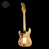 Electric guitar with a distressed finish on a black background, featuring the Tone Shop logo.