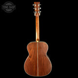 Back view of a wooden acoustic guitar with 'Tone Shop' logo in the corner.