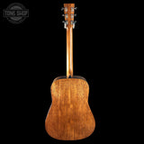 Back view of a wooden acoustic guitar on a black background with 'Tone Shop' logo.