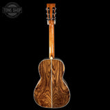 Back view of a wooden acoustic guitar with 'Tone Shop' logo.