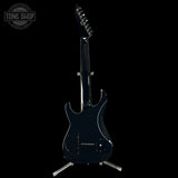 Black electric guitar on a stand with 'Tone Shop' logo in the corner.