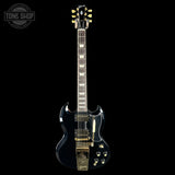 Black electric guitar with gold hardware on a black background, featuring the Gibson logo.