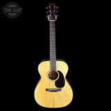 Acoustic guitar with a visible brand logo on a black background