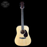 Acoustic guitar with a black pickguard on a white background, featuring the Tone Shop logo.