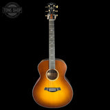 Acoustic guitar with a sunburst finish on a black background, featuring the Tone Shop logo.