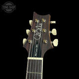 Guitar headstock with brand logo on a black background