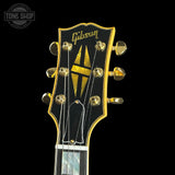 Gibson guitar headstock with gold tuning pegs on a black background