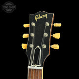 Gibson guitar headstock with tuning pegs on a black background