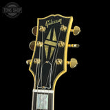 Gibson guitar headstock with gold tuning pegs on a black background