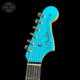 Close-up of a turquoise Fender guitar headstock on a black background