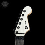 Close-up of a guitar headstock with a brand logo on a black background