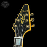 Gibson guitar headstock with gold tuning pegs on a black background