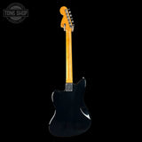 Black electric guitar with a blonde neck on a black background, featuring 'Tone Shop' logo.