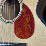 Close-up of a guitar with a red and gold flame pattern on a beige background