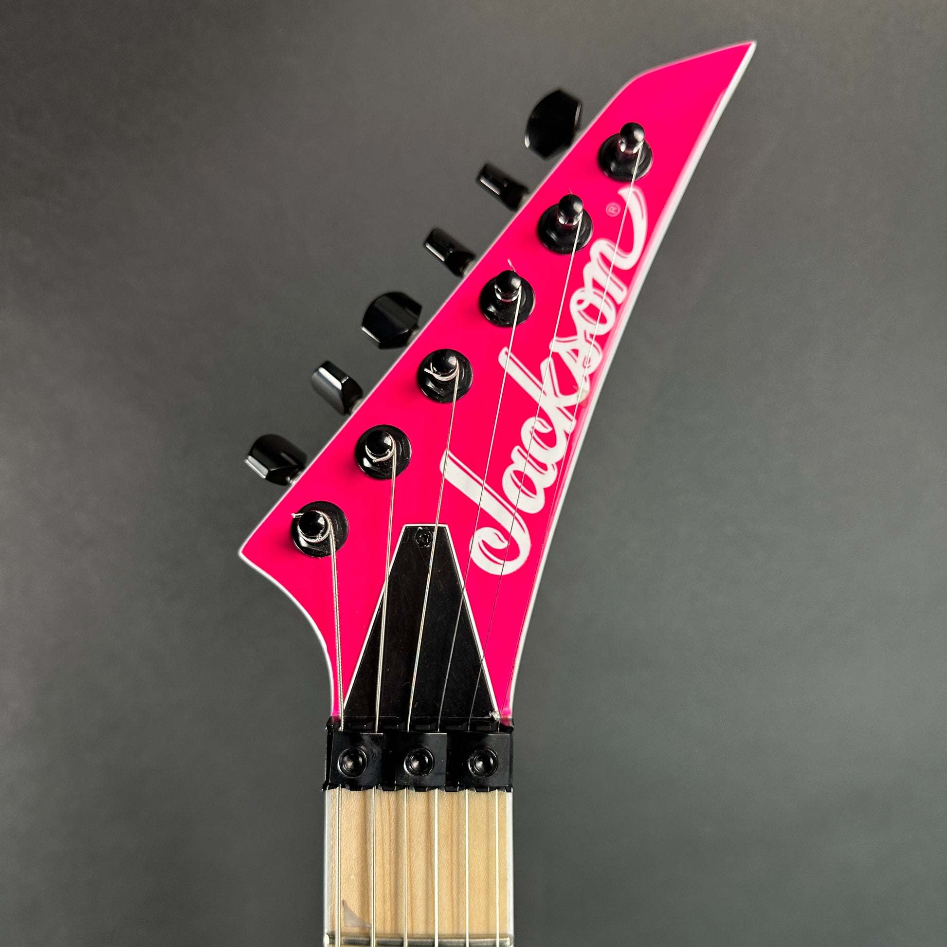 Front of headstock of Used Jackson Pro Series SL2M Magenta.
