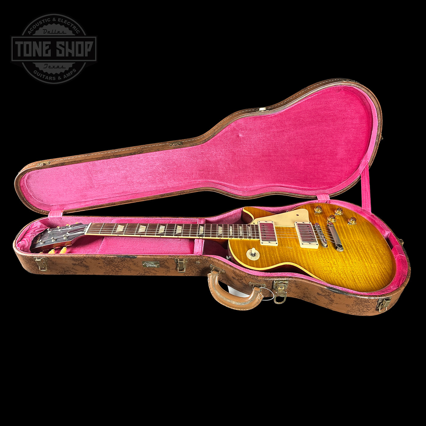 Gibson Les Paul guitar in a pink-lined case with 'Tone Shop' branding.