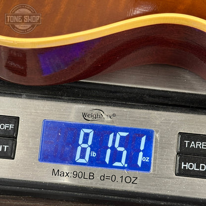 Guitar on a digital scale displaying weight, with 'Tone Shop' logo.