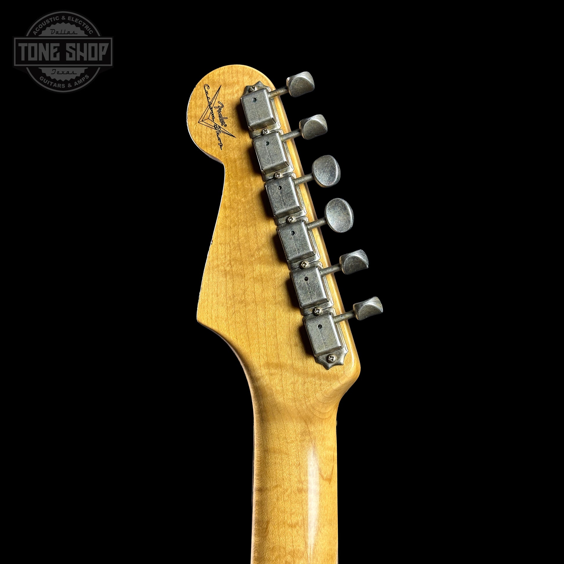 Guitar headstock with tuning pegs on a black background, featuring the Tone Shop logo.