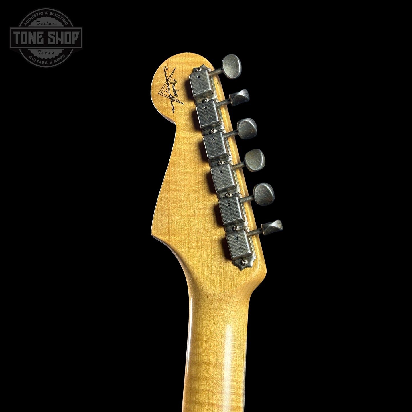 Guitar headstock with tuning pegs on a black background, featuring the Tone Shop logo.